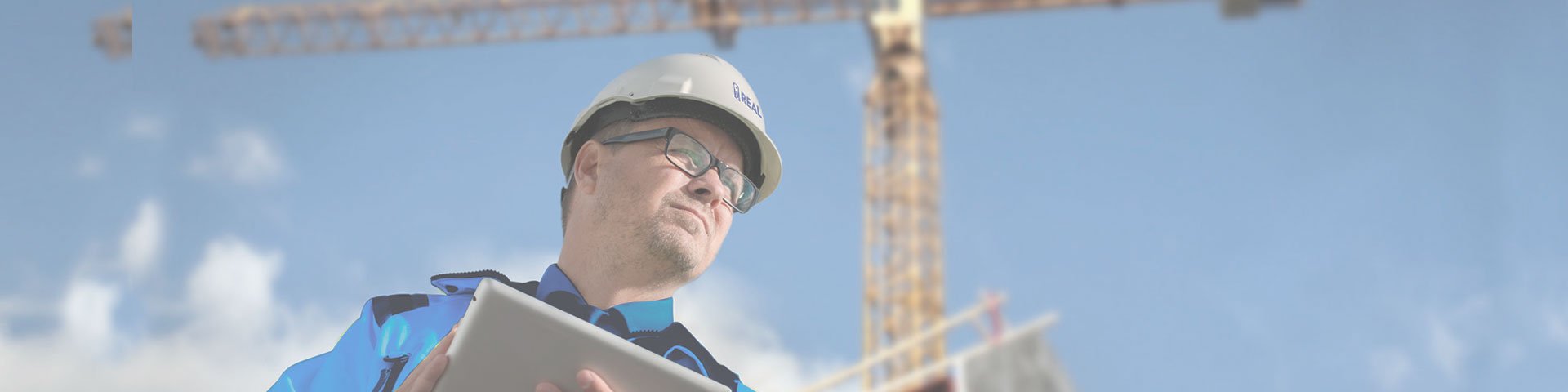 homem fazendo orçamento real guindastes com grua ao fundo e céu azul